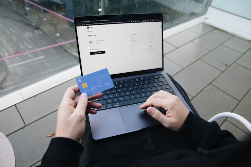 Pelanggan melakukan pembayaran online dengan laptop dan kartu kredit