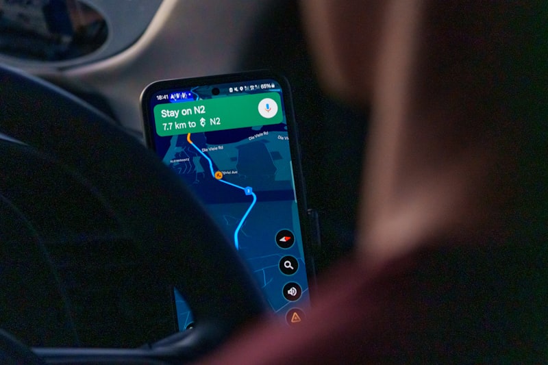 Person using navigation app on smartphone inside car.