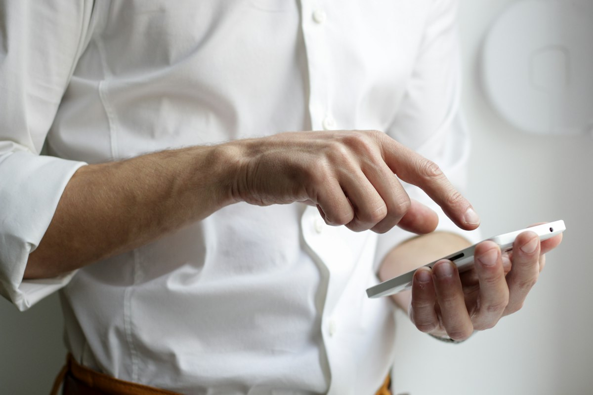 Pemilik usaha memegang smartphone untuk mengecek pembayaran