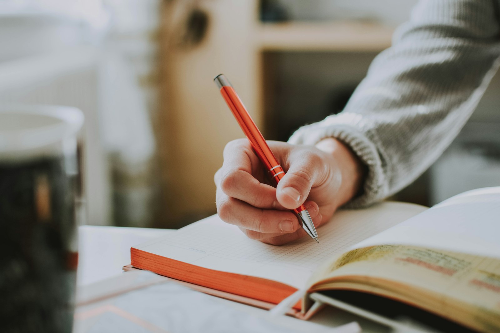 Tangan menyunting naskah copywriting website dengan pulpen merah