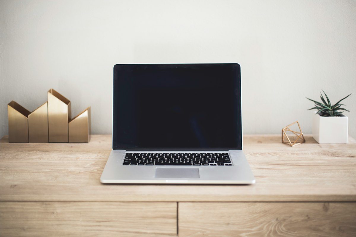 Laptop di atas meja untuk menyusun rencana dan anggaran website usaha